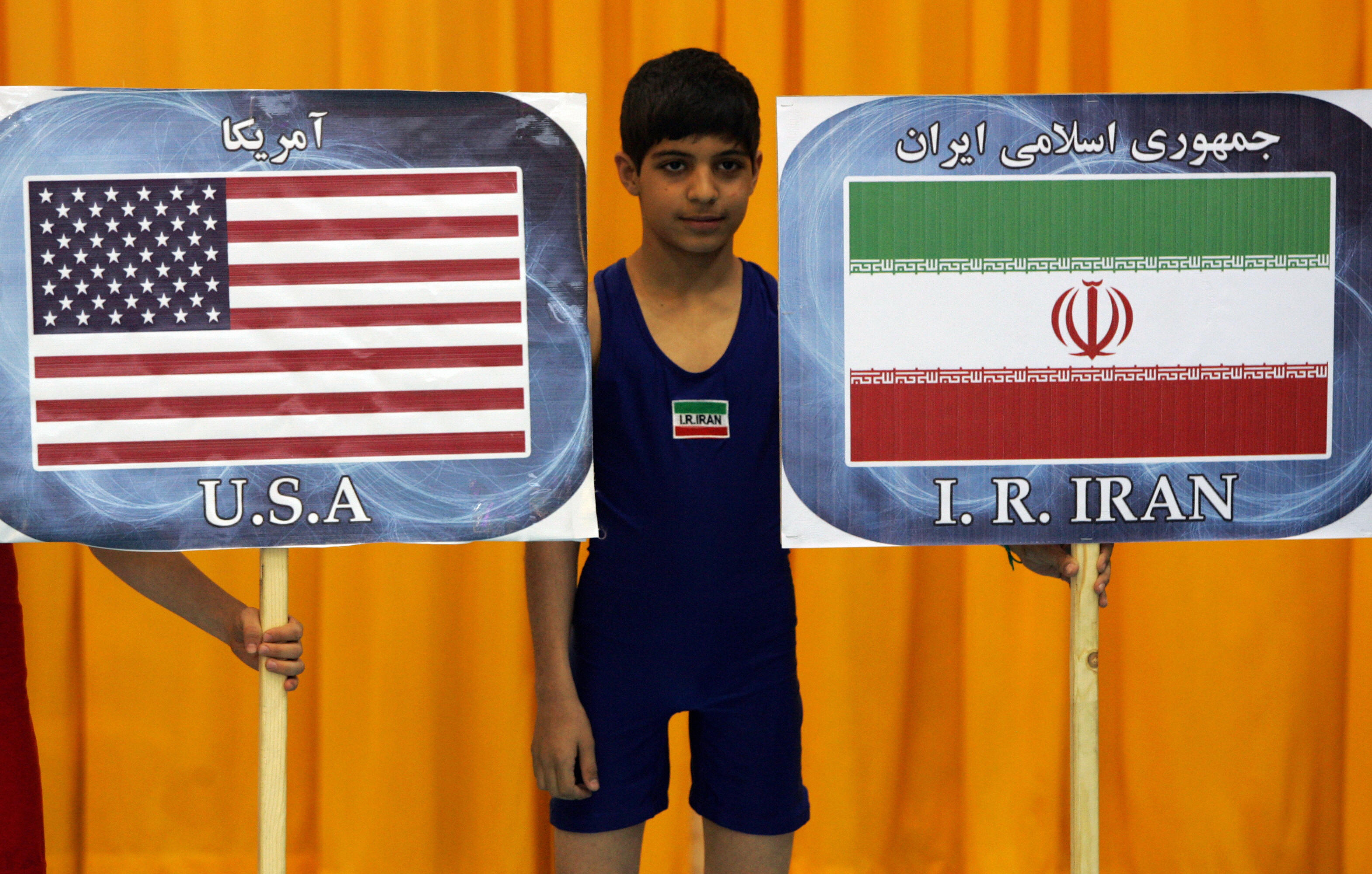 BEHROUZ MEHRI/AFP/Getty Images. An Iranian boy stands between the placards of Iran and United States during the opening ceremony of 29th international 'Takhti Cup' wrestling tournament in Tehran on March 12, 2009. A US wrestling team is competing in two-day the tournament in the Iranian capital. Even though Tehran and Washington have been bitter foes since Iran's 1979 Islamic Revolution, they have at times put aside their differences in the arena of sports.