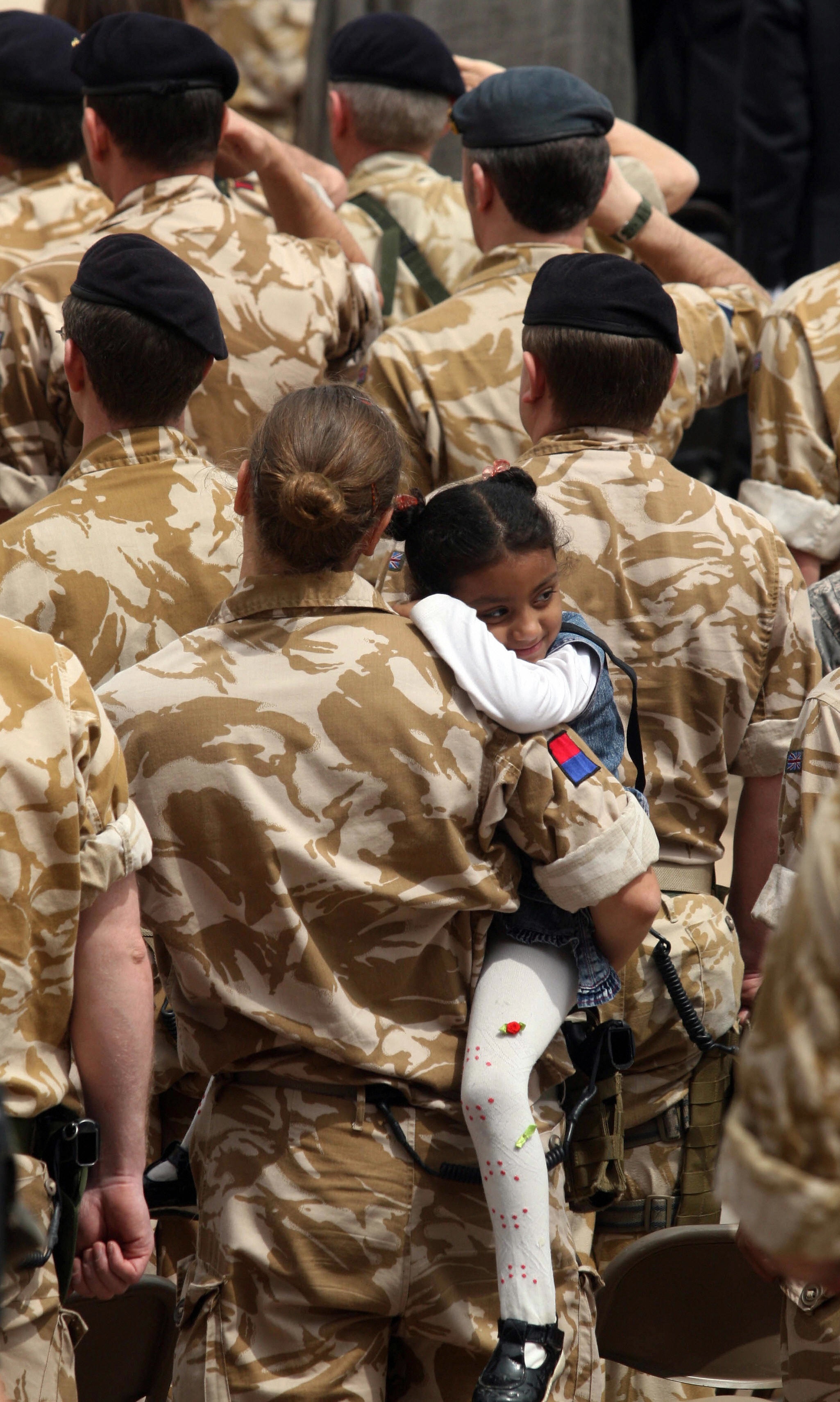 ESSAM AL-SUDANI/AFP/Getty Images. A British military woman holds an Iraqi girl while attending a handover ceremony marking the pullout of the British army from Iraq at Basra airport on March 31, 2009.