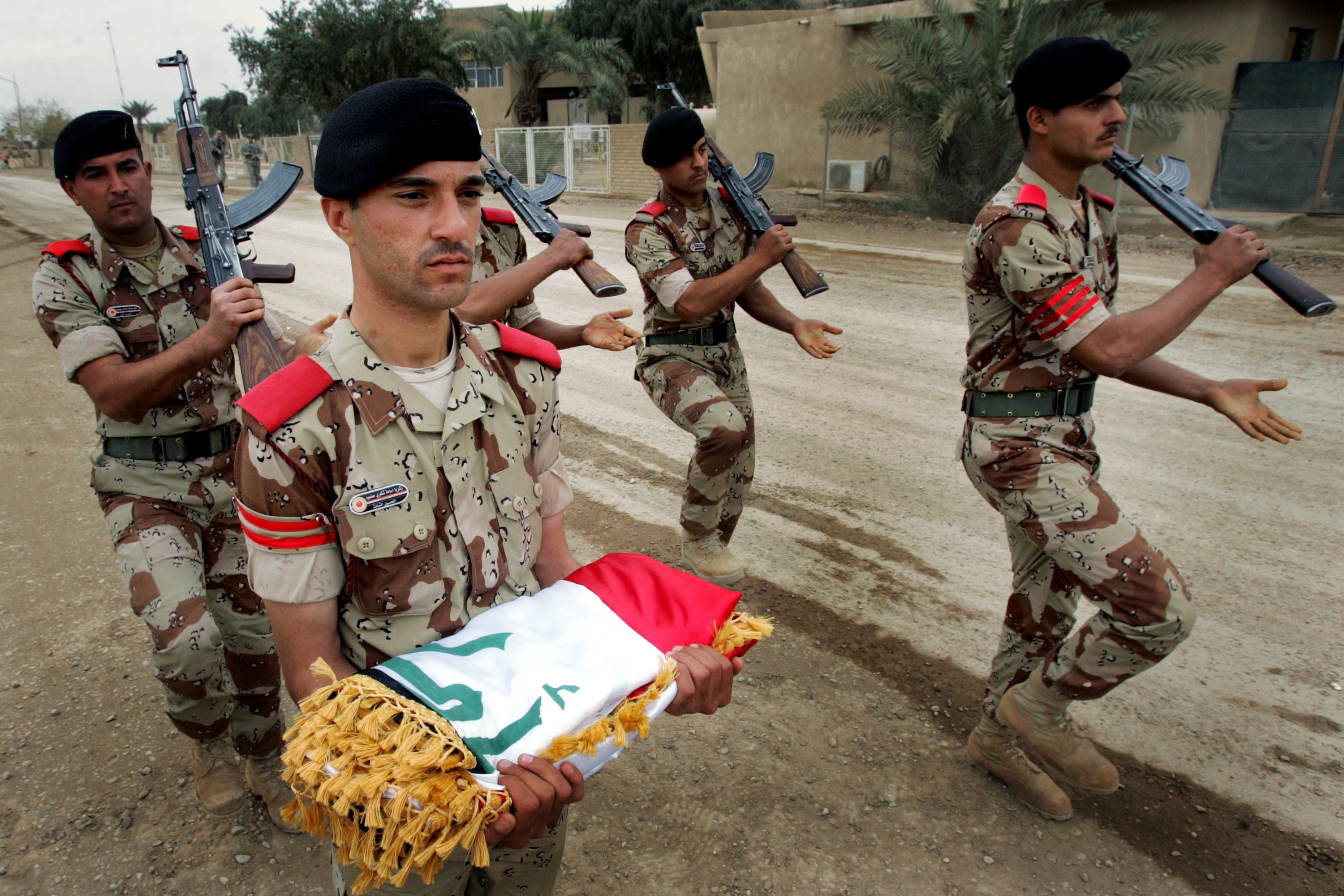 Wathiq Khuzaie/Getty Images. BAGHDAD, IRAQ, MARCH 31: Iraqi Army soldiers march while carrying a flag during a handover ceremony at Camp Rustimiyah March 31, 2009 in Baghdad, Iraq. The U.S Army handed over the Rustimiyah military camp back to the Iraqi army , which houses the Iraqi Military Academy and is about seven square kilometers of terrain with 200 buildings, during the ceremony.