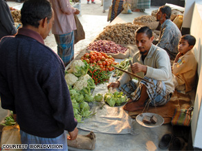 A local man buys food at a marketplace in Bangladesh.