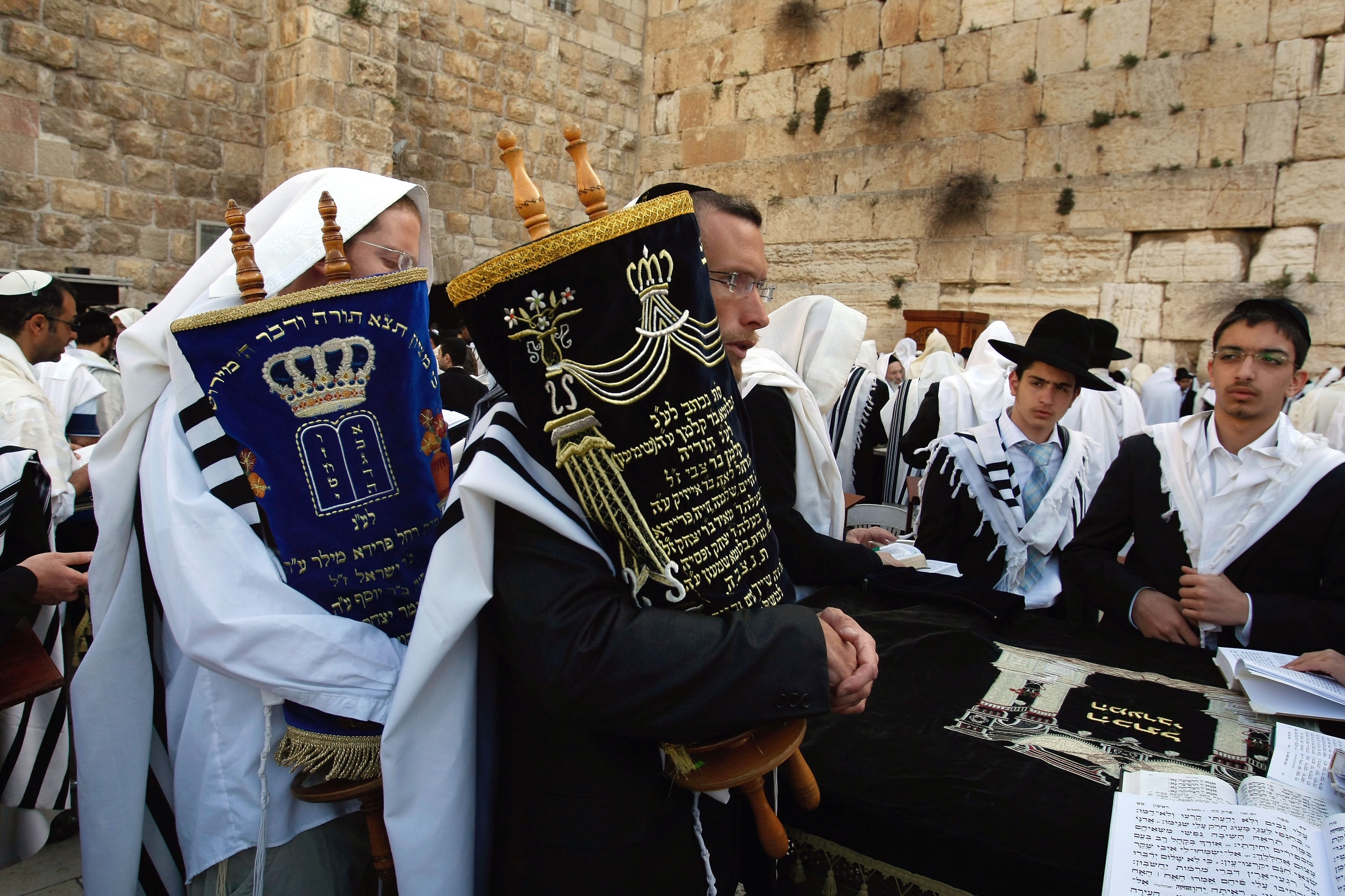 David Silverman/Getty Images. Jewish men carry Torah scrolls during morning prayers at the Western Wall on April 13, 2009 in Jerusalem's Old City.