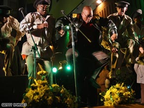 Zuma (center) jumps in the air as he celebrates on stage with supporters.