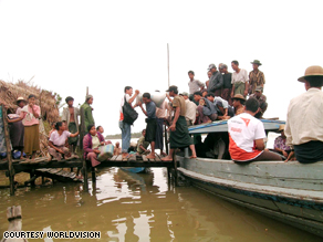 World Vision relief workers travel from village to village to distribute emergency supplies.  In the months following the storm, there was often not enough land in the water-logged country to distribute supplies, so aid agencies would travel by boat.