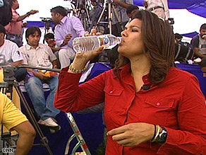 CNN correspondent Sara Sidner gulps down water during a sweltering rally.