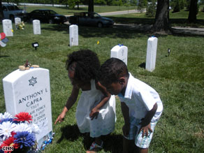 Ayala and Avery Alexander examine the headstone of US Air Force Tech Sgt. Anthony Capra at Arlington National Cemetery's Section 60. Their father's headstone is just a few yards away. He died in Afghanistan months before they were born.