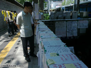 A man reads messages of condolence posted at the City Hall subway stop in Seoul.