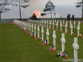 Cannons fire a 21-gun salute at Colleville-sur-Mer during D-Day commemorations.