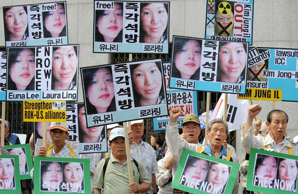 South Korean conservative activists hold up pictures of US journalists Laura Ling and Euna Lee, detained by the authorities in North Korea, during a rally calling for their freedom in Seoul on June 4, 2009. Getty Images