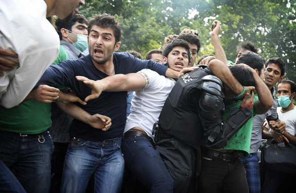 Supporters of defeated Iranian presidential candidate Mir Hossein Mousavi help evacuate an injured riot police officer after he was beaten by demonstrators during a protest in Valiasr Street in Tehran on June 13, 2009. Getty Images