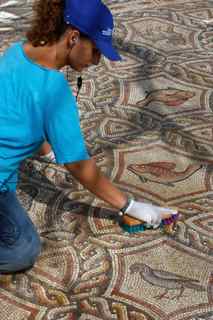 David Silverman/Getty Images. A worker cleans the dirt off an ancient Roman mosaic as it is revealed some 13 years after it was first discovered in the ruins of a 4th century AD building, on July 1, 2009 in Lod in central Israel.