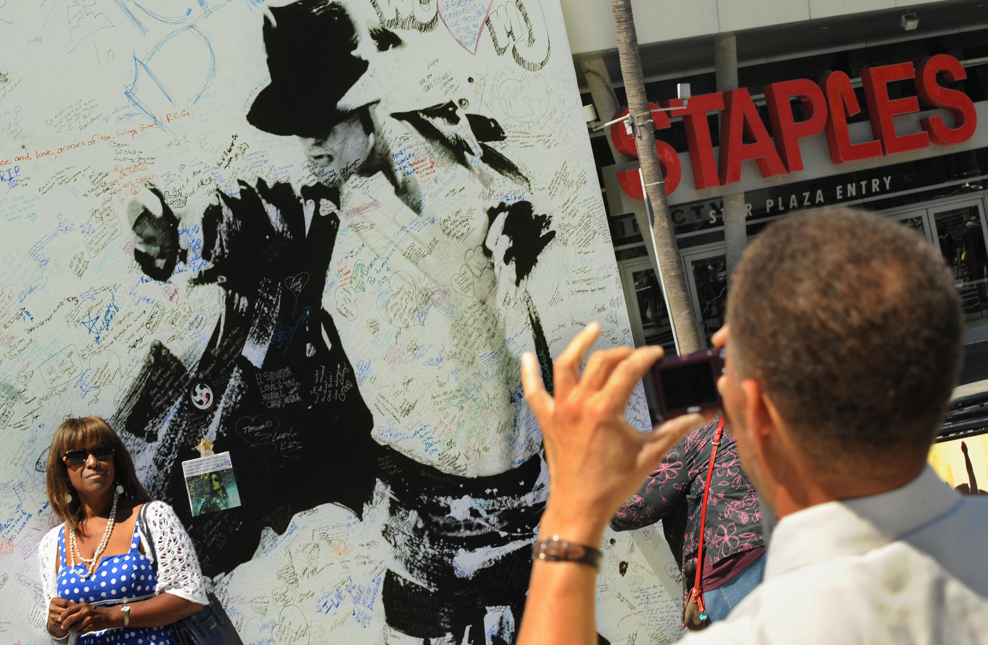 (Getty Images) Fans take photos of a Michael Jackson billboard covered in messages outside the Staples Center in Los Angeles on July 5, 2009.