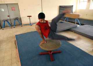 MOHAMMED SAWAF/AFP/Getty Images. An Iraqi youth trains at a gymnasium on the outskirts of the southern city of Karbala, some 110 kms from Baghdad, on July 12, 2009.