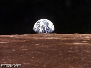 A view of the Earth appears over the Lunar horizon as the Apollo 11 Command Module comes into view of the Moon before Astronauts Neil Armstrong and Edwin Aldrin Jr. leave in the Lunar Module, Eagle, to become the first men to walk on the Moon's surface.