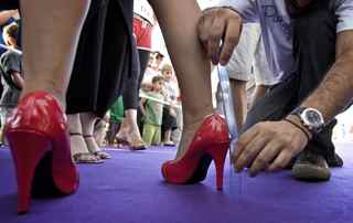JONATHAN NACKSTRAND/AFP/Getty Images. An organiser measures the length of an Israeli woman's heel prior to the 'Race on Heels' near the beach in Tel Aviv on July 16, 2009. The competition came to Israel for the first time after being held in Amsterdam, New York and Berlin. During the race all women are asked to run on heels above 7 centimetres on a 50-metre track.