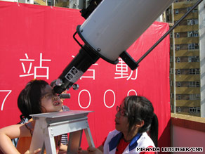 A girl peers through a telescope Wednesday in Hong Kong to witness the solar eclipse.