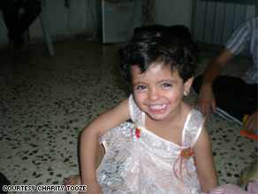 Three-year-old Saba Fahed, an Iraqi refugee, plays with Legos on the floor of her family's apartment.