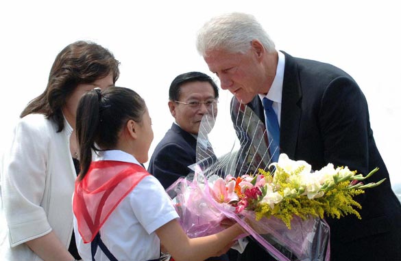 This photo taken on August 4, 2009 and released by North Korea's official Korean Central News Agency shows former US president Bill Clinton (R) receiving a bouquet of flowers from North Korean girl upon his arrival at Pyongyang airport. (KNS/AFP/Getty Images)