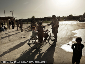 U.S. Marines play with local children during a patrol into the village of Jakar in Nawa district. 