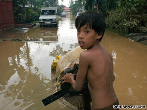 A boy wades through the waters in Marietta Romeo, a middle-class neighborhood in eastern Manila.