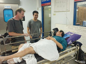 CNN's cameraman Mark Phillips, producer Andy Saputra and survivor John Lee chat in a hospital.