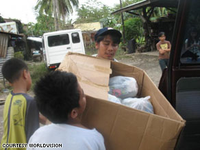 Efren and other volunteers load donated items into a vehicle to begin distributing them to families in need throughout Cavite, Philippines.