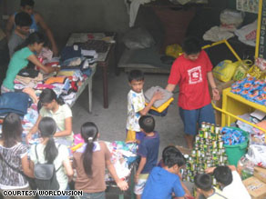 Volunteers with Efren's group, Dynamic Teen Company, sort donated clothes and prepare to distribute them to families in need in Cavite, Philippines.