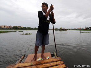 A farmer crosses a flooded rice paddy on the outskirts of Manila.