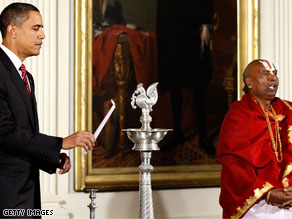 President Barack Obama lights a traditional oil lamp as Sri Narayanachar Digalakote, Hindu Priest from the Sri Siva Vishnu Temple in Maryland, chants in observance of Diwali, or the 'Festival of Lights.'