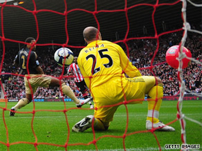 Sunderland striker Darren Bent (obscured) shoots towards goal and the ball hits a beach ball that had been blown onto the pitch.