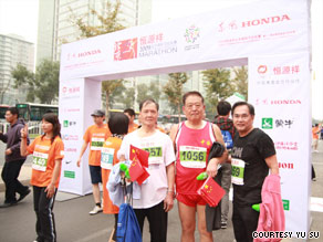 Jaime FlorCruz, far right, joins Zhang Lianqi, center, and another runner at the finish line.