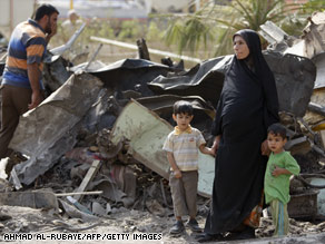 An Iraqi woman and her two little boys survey the damage after a suicide truck bomb struck in central Baghdad over the weekend. The near-simultaneous twin suicide vehicle bomb attacks were the deadliest in the violence-wracked country in over two years.