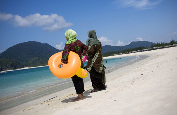 Two women stand alone on a beach in a region of Banda Aceh devastated by the tsunami.