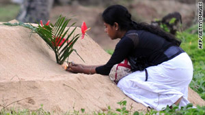 A woman remembers victims of the 2004 tsunami with flowers and candles in Peraliya, Sri Lanka, on Saturday.
