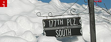 Snow piled higher than street sign