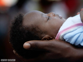 A woman holds an orphaned infant at a Port-au-Prince orphanage.