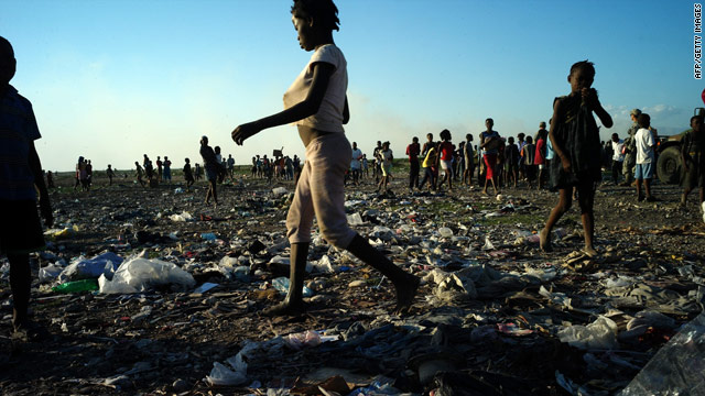 A woman walks through a Haitian shantytown.