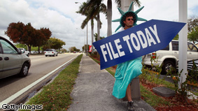 Craig Baldwin holds a sign advertising a tax preparation office for people that still need help completing their taxes before the Internal Revenue Service deadline on April 14, 2010 in Miami, Florida.
