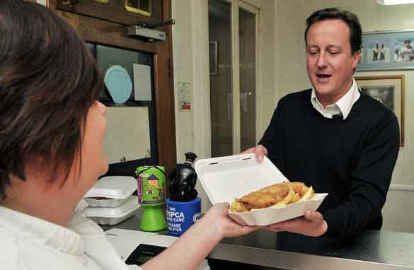 Conservative Party leader David Cameron buys food in a fish and chip shop in Long Town village on Tuesday during a non-stop 24-hour campaigning session before the general election. (AFP/Getty Images)