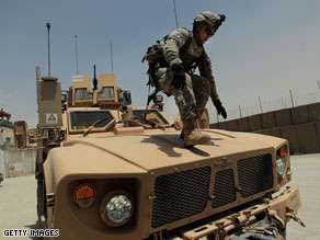 A soldier from the 10th Mountain Division walks down a vehicle in Afghanistan. A new poll indicates most Americans support President Barack Obama's timetable for withdrawal.