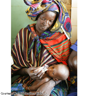 Zeinaba Abdoulaye feeds her 8-month-old daughter, Tinoumoude Guissa, with Plumpy'Nut, a read-to-use therapeutic food, at a World Vision health center in Niger. Zeinaba left her village at 6 a.m. and walked seven kilometers to bring Tinoumoude to the health center because the baby had had a fever for the past several days.  Zeinaba and her husband have two other children at home, but she says there is no millet left in the house to feed her family.
