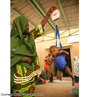 A community health volunteer weighs 12-month-old Mariam at a health center in Koma Bangou, Niger.  Mariam lives with her 19-year-old mother, Baraka, nearby.  Baraka said she cried when she found out her daughter was severely malnourished. She said she would like to feed her child but often has no food to give her.