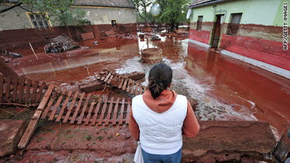 A woman surveys the damage in Devecser, Hungary after the village was floodedby toxic red sludge from a local aluminium plant.