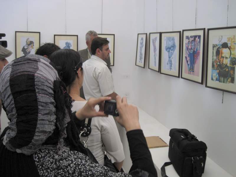 Spectators view works from Iraq's largest exhibition of political cartoons (CNN/Mohammed Tawfeeq)