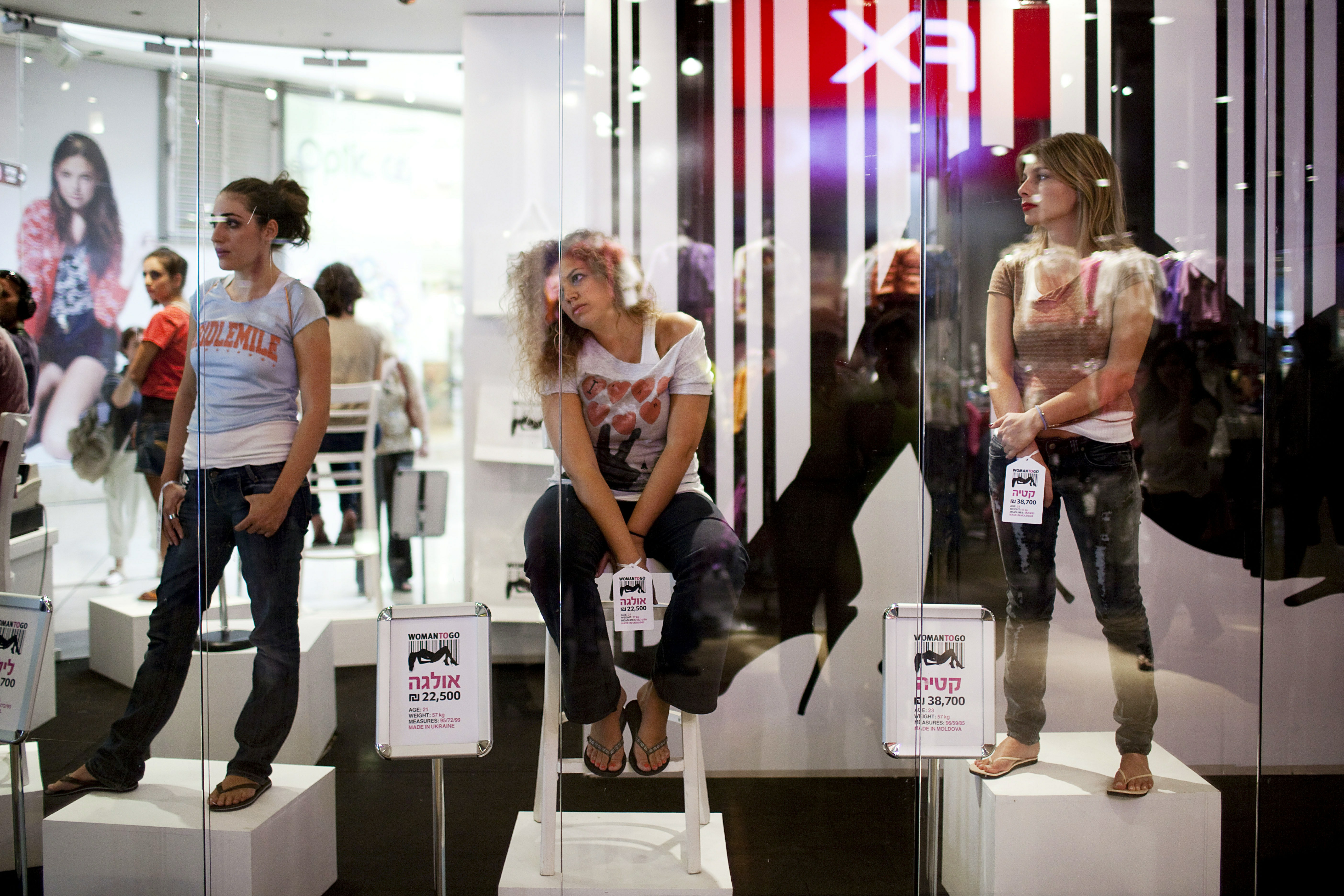 Women stand in a store window at a shopping mall with price tags on their hands (Photo by Uriel Sinai/Getty Images)