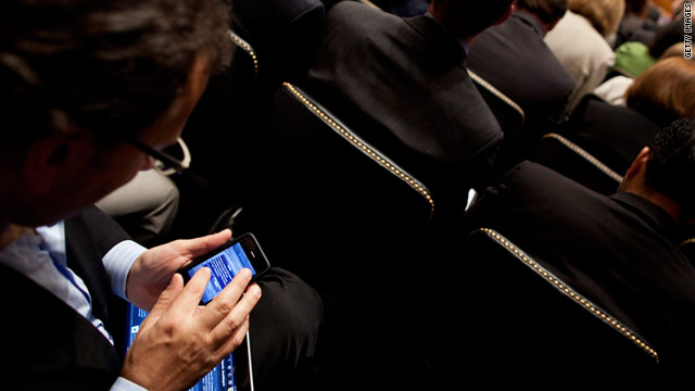 A man checks what appears to be an iPhone while attending a Senate privacy hearing with Apple and Google executives.