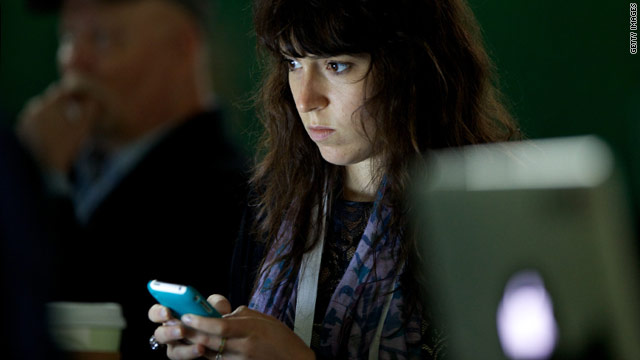 A woman attending last week's TechCrunch Disrupt, an event geared toward technology startups, checks her smartphone.