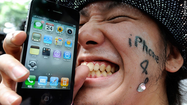 An Apple fan holds his new iPhone 4 phone with glee on the day of its release in June 2010.