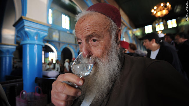 A rabbi drinks a glass of fig alcohol at the 2010 pilgrimage to Derba, a Tunisian island