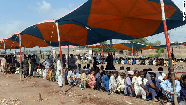 Pakistani flood-affected people queue up at a relief camp in the flood-hit Badin district on September 29, 2011.