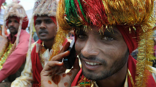 An Indian talks on his mobile phone during a mass marriage ceremony for some 525 poverty-stricken couples from the India-Pakistan border area on April 13, 2009. 